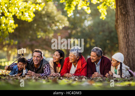 Uomo con gioiosa famiglia tenendo selfie Foto Stock