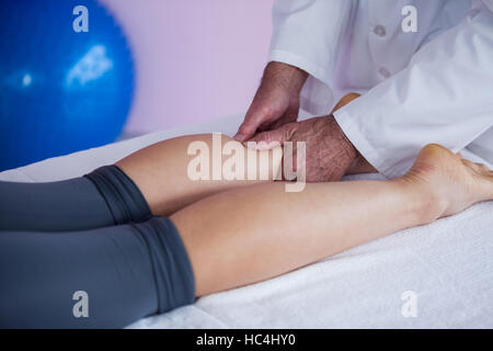 Fisioterapista dando massaggio delle gambe di una donna Foto Stock