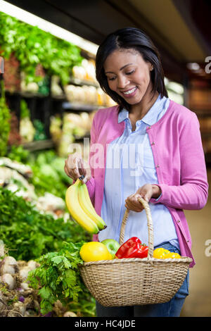 Donna acquisto di banana in sezione biologica Foto Stock