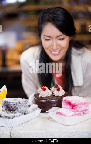 Donna felice la selezione di dessert da visualizzare Foto Stock