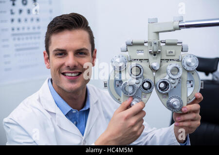 Sorridere all'ottico optometrista phoropter di regolazione Foto Stock