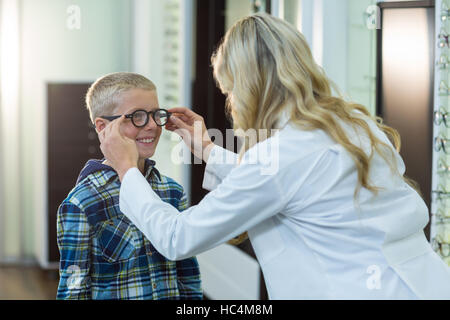 All'ottico optometrista femmina la prescrizione di occhiali per i pazienti in giovane età Foto Stock
