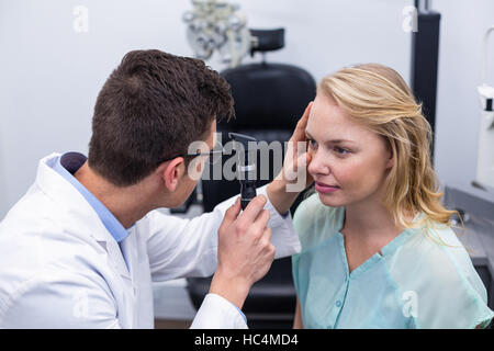 All'ottico optometrista esame paziente femmina attraverso oftalmoscopio Foto Stock