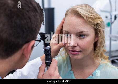 All'ottico optometrista esame paziente femmina attraverso oftalmoscopio Foto Stock