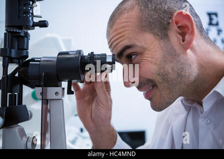 All'ottico optometrista cerca attraverso biomicroscope Foto Stock