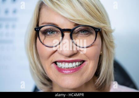 Bella donna indossa occhiali in negozio OTTICA Foto Stock