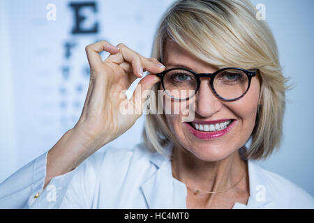 Donna sorridente all'ottico optometrista indossa occhiali Foto Stock