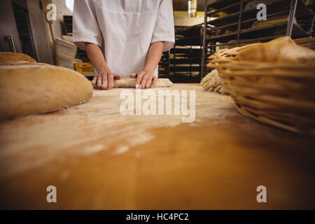 Metà sezione femminile di baker impastare un impasto Foto Stock