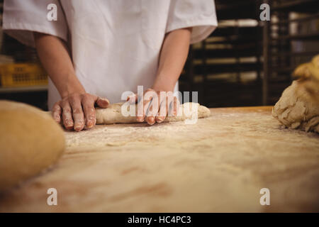 Metà sezione femminile di baker impastare un impasto Foto Stock