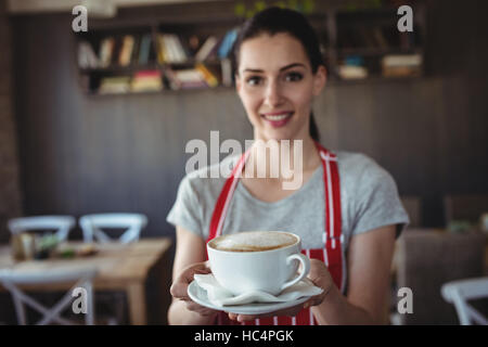 Il panettiere femmina tenendo una tazza di caffè Foto Stock