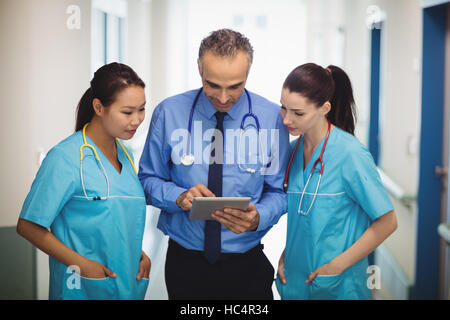 Medico e infermiere discutendo su tavoletta digitale Foto Stock