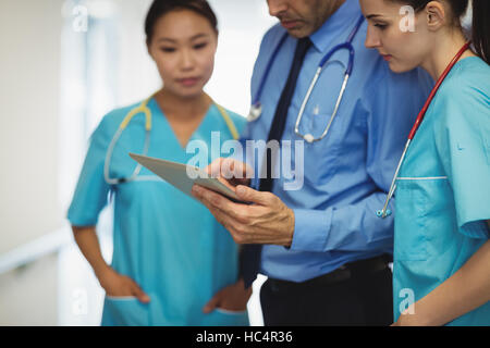 Medico e infermiere discutendo su tavoletta digitale Foto Stock