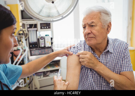 Medico donna dando una iniezione di un paziente Foto Stock