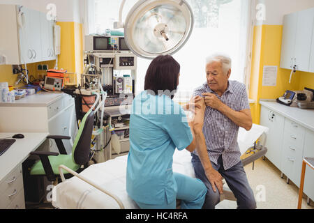 Medico donna dando una iniezione di un paziente Foto Stock