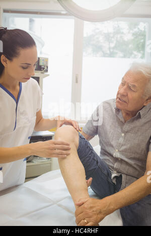 Medico donna esaminare pazienti ginocchio Foto Stock