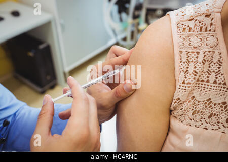 Close-up del medico di sesso maschile di dare una iniezione di un paziente Foto Stock