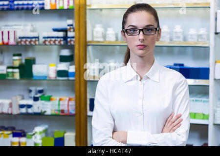 Il farmacista in piedi con le braccia incrociate in farmacia Foto Stock
