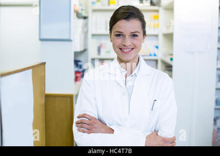 Il farmacista in piedi con le braccia incrociate in farmacia Foto Stock