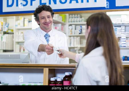 Il farmacista che ricevono il pagamento da parte del cliente Foto Stock