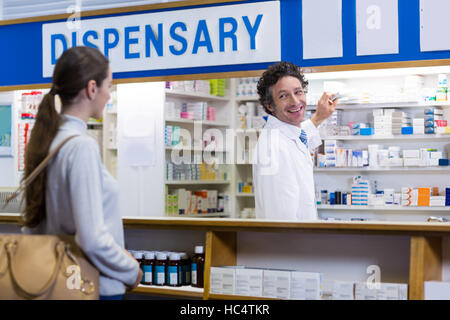 Il farmacista che mostra la casella di medicina per il cliente Foto Stock