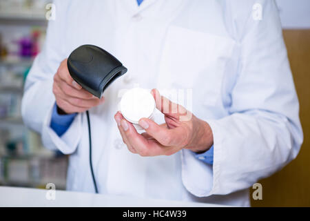 Il farmacista utilizzando uno scanner di codici a barre sul contenitore della medicina Foto Stock