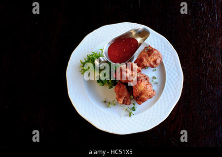 Grigliata di ali di pollo con il piccante salsa di pomodoro in piastra bianca Foto Stock