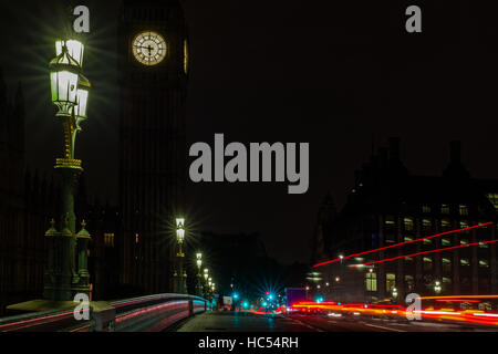 Big Ben, Westminster Bridge al mattino presto. Con semafori e auto sentieri di luce. Una forte luce di strada in primo piano. Immagine drammatica con impatto Foto Stock