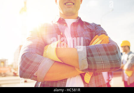 Close up di sorridere builder mani in guanti Foto Stock