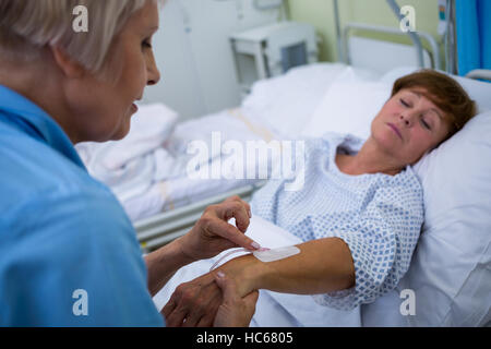Fissaggio infermiere flebo IV su pazienti a mano Foto Stock
