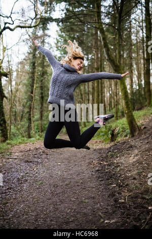 Bella donna che si tuffa in foresta Foto Stock