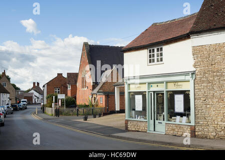 Scena di strada nel villaggio di Harbury, mostrando la biblioteca e le unghie e salone di bellezza, Warwickshire, Inghilterra, Regno Unito Foto Stock