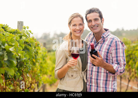 Ritratto di coppia felice tiene in vetro e una bottiglia di vino Foto Stock