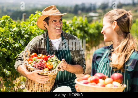 Felice agricoltore giovane azienda cesti di frutta e verdura Foto Stock