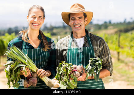 Ritratto di felice agricoltore giovane azienda ortaggi in foglia Foto Stock