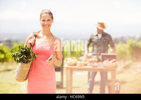 Ritratto di donna cliente in piedi di fronte a stallo vegetale Foto Stock