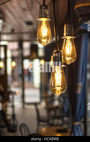 Old Style Glowing Light Bulbs Hanging in Bar Foto Stock