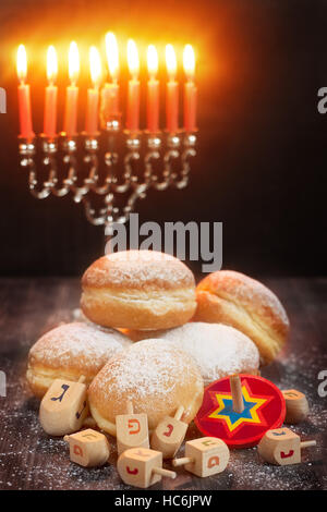 Simboli della festa ebraica hanukkah - menorah, ciambelle e sufganiyot dreidels Foto Stock