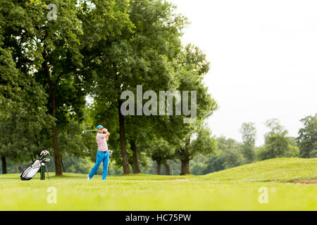 Giovane uomo giocando a golf sul campo da golf Foto Stock