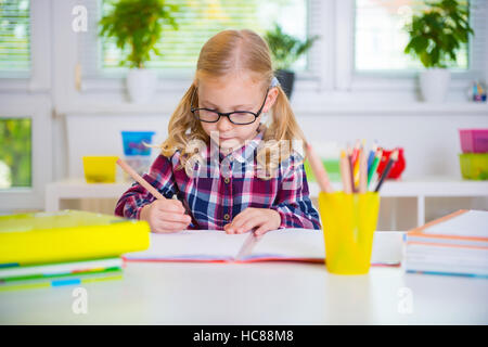 Molto diligente ragazza in bicchieri impara a scuola Foto Stock