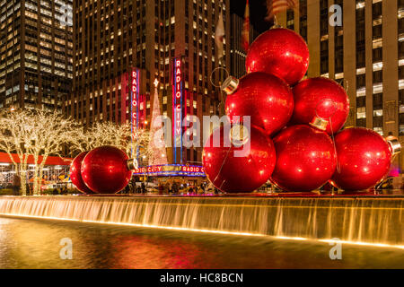 Rossa gigante ornamenti vacanza sulla 6th Avenue. Stagione di Natale decorazioni. Midtown. La città di New York Foto Stock