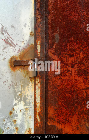 Primo piano di un lucchetto sulla vecchia vernice porta arrugginito Foto Stock