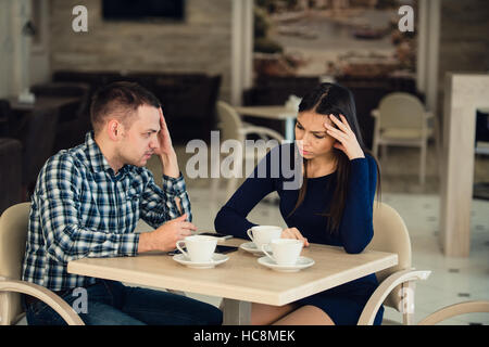 Coppia giovane sostenendo in una caffetteria. Lei ne ha avuto abbastanza, ragazzo è importante scusarsi. Problemi di relazione. Foto Stock