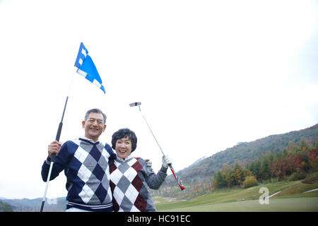 Ritratto di sorridente coppia senior golfisti avvolgente Foto Stock