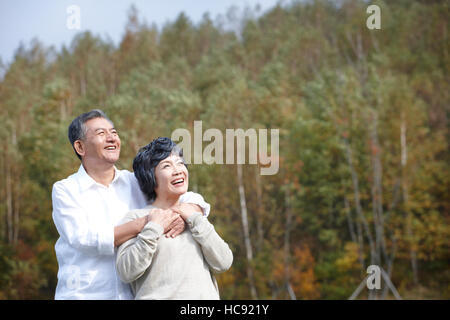 Sorridente coppia senior abbracciando cercando fino all'aperto Foto Stock