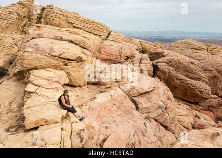 Escursionista femmina tenendo in vista da una montagna rocciosa top in Red Rock Canyon National Conservation Area vicino a Las Vegas, Nevada. Foto Stock