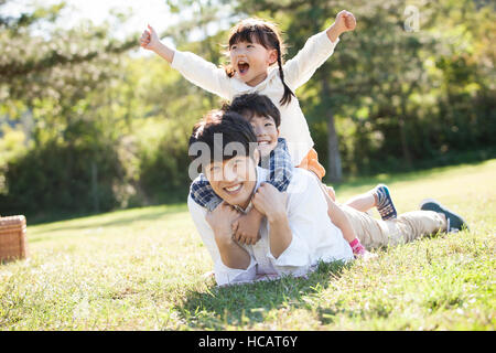 Padre amorevole con il figlio e la figlia per divertirsi durante il picnic Foto Stock