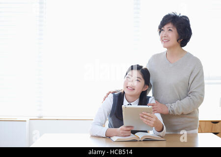 Sorridente middle school girl e sorridente madre cercando Foto Stock