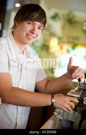 Giovane cameriere toccando la birra Foto Stock