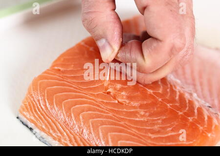 Rimuovere le ossa di filetto di salmone. Rendendo il salmone in pasta sfoglia serie. Foto Stock