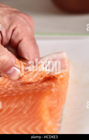 Rimuovere le ossa di filetto di salmone. Rendendo il salmone in pasta sfoglia serie. Foto Stock